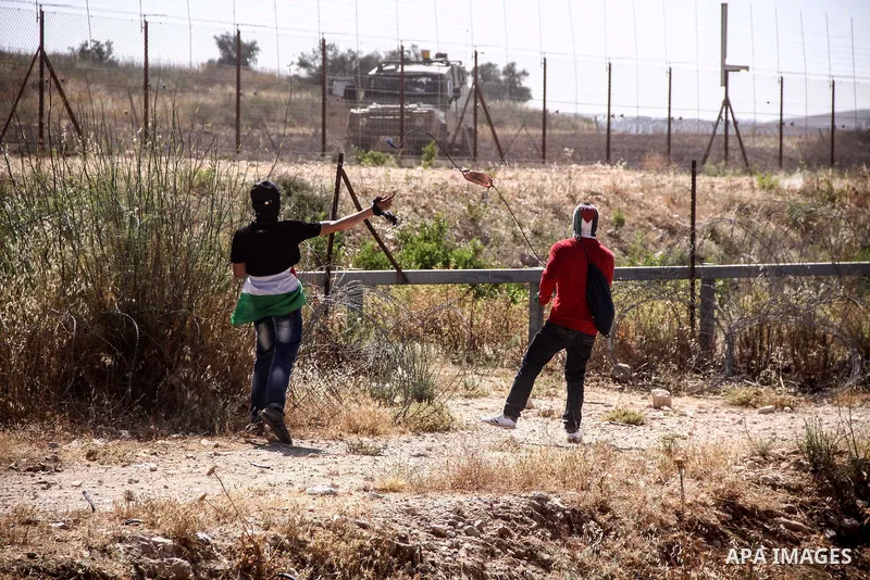 Palestinian demonstrators and Israeli forces clash after a protest by Palestinians calling for the return of displaced Palestinians to their villages occupied by Israel in 1967, in the West Bank village of Beit Nuba, nea...