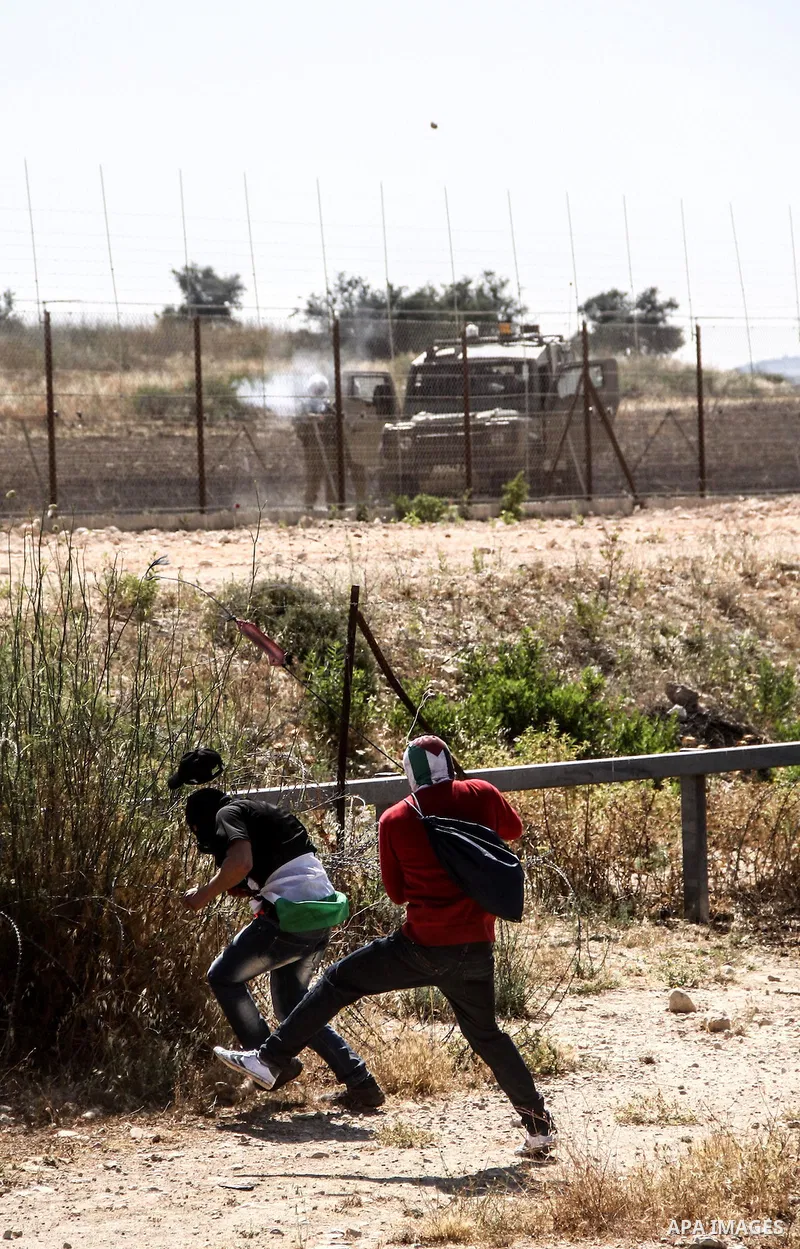 Palestinian demonstrators and Israeli forces clash after a protest by Palestinians calling for the return of displaced Palestinians to their villages occupied by Israel in 1967, in the West Bank village of Beit Nuba, nea...