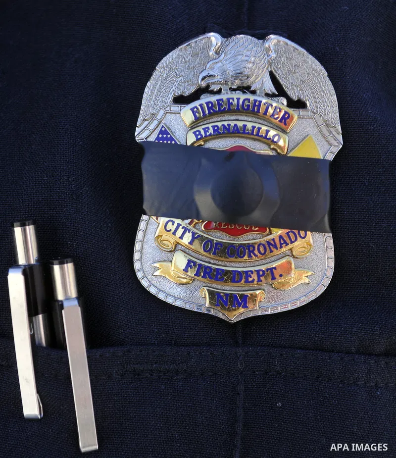 June 9, 2012 - Bernalillo, NM, U.S. - 060912.Town of Bernalillo and Sandoval County firefighter Matthew Miller wears his badge in honor of Edward ''Eddie'' Marquez, who was buried, Saturday, June 9, 2012. Marquez was a B...