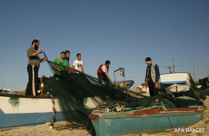 Palestinians fishermen repair their nets at the beach of Rafah city on June 10, 2012 Fishermen, suffer from the tightening of the Israeli siege imposed on Palestinian fishermen a forbidden fishermen by Israel to enter th...