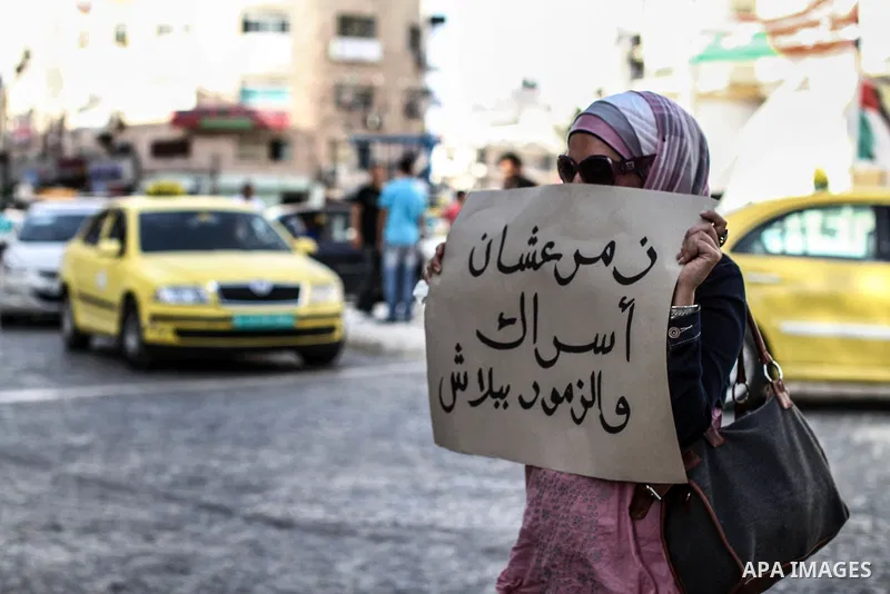 Palestinians hold banners and call the drivers to blow their horns during a demonstration solidarity with Palestinian prisoners whose still on hunger strike in Israeli jails, in the West Bank city of Ramallah, on 10 June...