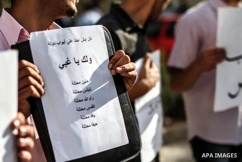 Palestinians hold banners and call the drivers to blow their horns during a demonstration solidarity with Palestinian prisoners whose still on hunger strike in Israeli jails, in the West Bank city of Ramallah, on 10 June...