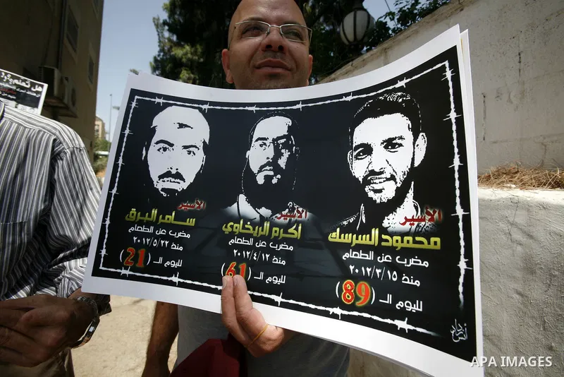 Palestinians and Foreigners hold posters depicting prisoners Mahmoud Al-Sarsak, and Akram al-Rekhawi during a rally in solidarity with them in the red cross offices in jerusalem city, on June 11, 2012. Photo by Mahfouz A...