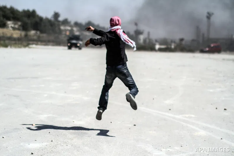 A Palestinian protester throws stones toward Israeli police during clashes in front of Ofer prison, near the city of Ramallah, after a demonstration solidarity with prisoners Mahmud Sarsak, prisoners Akram Rikhawi and Sa...