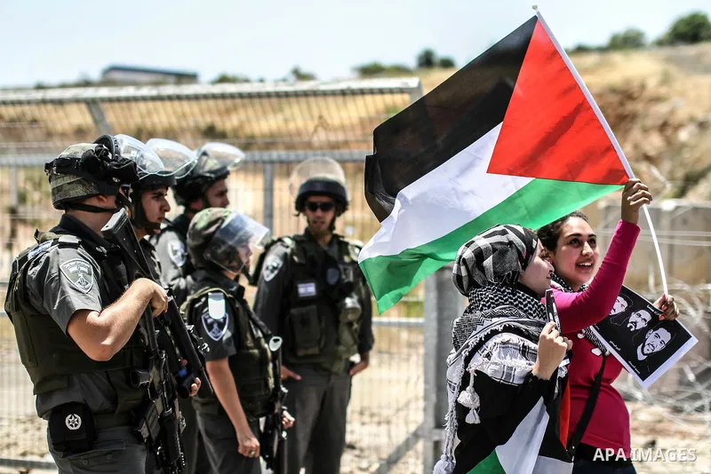 Female Palestinian protestors hold pictures of jailed Palestinian football player Mahmud Sarsak (R) and prisoners Akram Rikhawi (C) and Samir Al-Baraka during a demonstrating in front of Ofer prison, near the city of Ram...