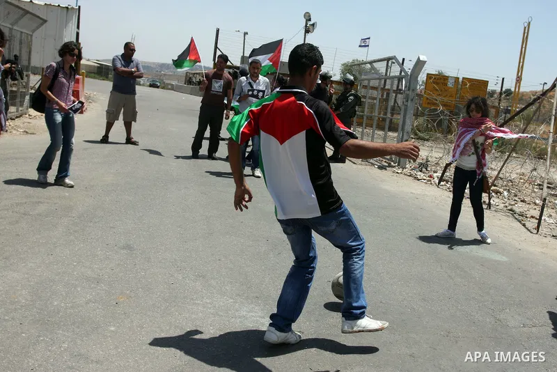 Israeli police keep guard as Palestinian protestors play football in front of Ofer prison, near the city of Ramallah, in solidarity with jailed Palestinian football player Mahmud Sarsak and prisoners Akram Rikhawi and Sa...