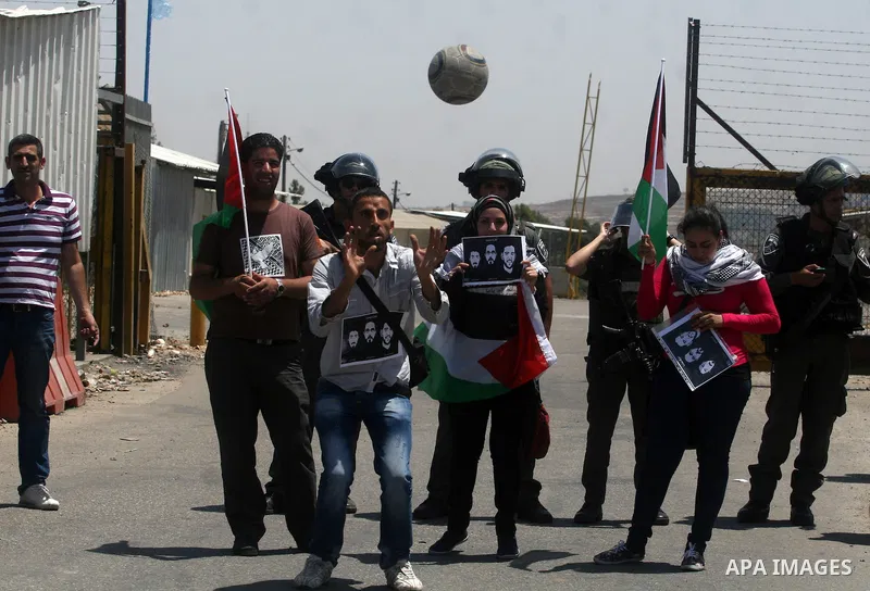 Israeli police keep guard as Palestinian protestors play football in front of Ofer prison, near the city of Ramallah, in solidarity with jailed Palestinian football player Mahmud Sarsak and prisoners Akram Rikhawi and Sa...