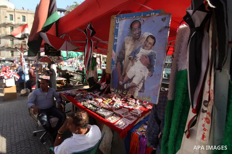 A man show digitally manipulated pictures depicting Egypt's former president Hosni Mubarak and Field Marshal Mohamed Hussein Tantawi, at Tahrir square in Cairo on June 11, 2012. Photo by Majdi Fathi