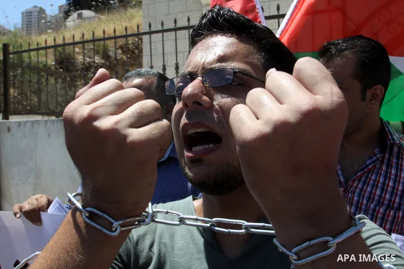 Palestinian protestors hold pictures of Palestinian prisoners Mahmoud Al-Sarsak and Akram al-Rikhawi, whose are still refusing food for 86 days after a deal was made to end a mass prisoner hunger strike, during a demonst...