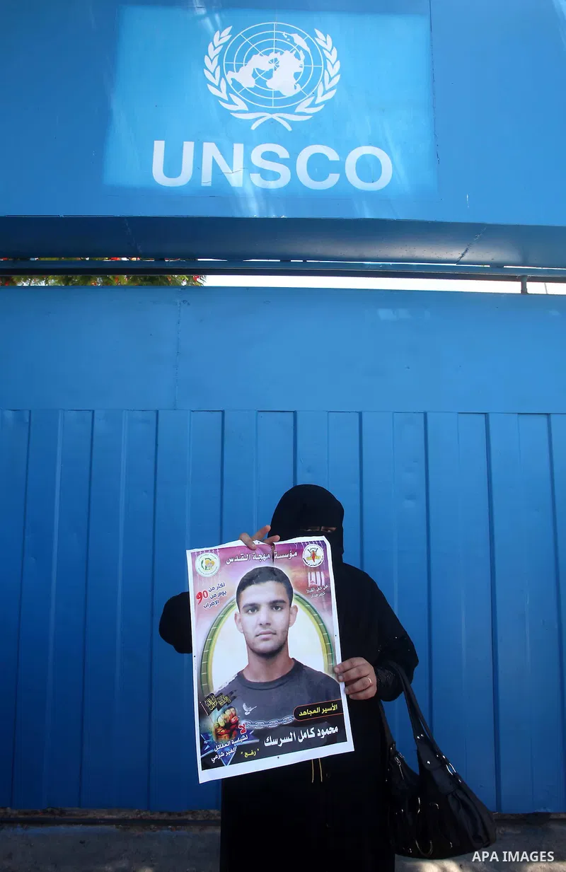 A Palestinian woman holds pictures of Palestinian prisoners Mahmoud Al-Sarsak and Akram Al-Rikhawi, whose are still refusing food for 86 days after a deal was made to end a mass prisoner hunger strike, during a demonstra...