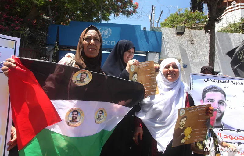 Palestinian women hold pictures of Palestinian prisoners Mahmoud Al-Sarsak and Akram Al-Rikhawi, whose are still refusing food for 86 days after a deal was made to end a mass prisoner hunger strike, during a demonstratio...