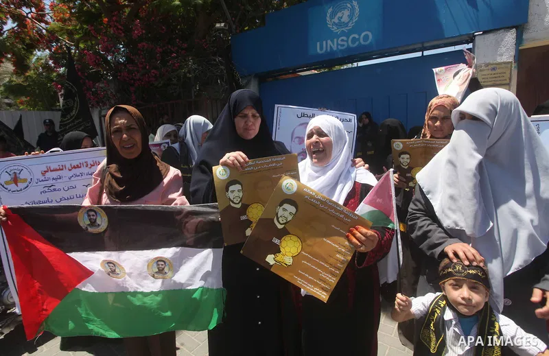 Palestinian women hold pictures of Palestinian prisoners Mahmoud Al-Sarsak and Akram Al-Rikhawi, whose are still refusing food for 86 days after a deal was made to end a mass prisoner hunger strike, during a demonstratio...