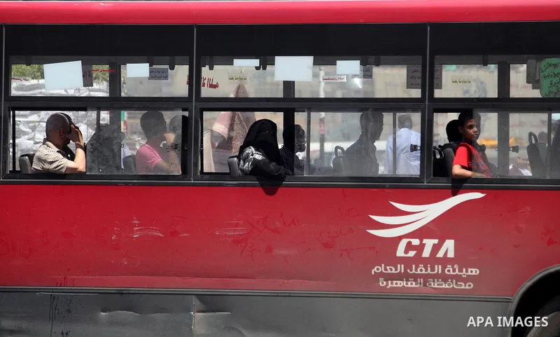 Egyptians rides bus in front of a defaced campaign election banners of presidential candidate and former prime minister Ahmed Shafik in Cairo June 12, 2012. The run-off on June 16 and 17 is the last stage in Egypt's firs...