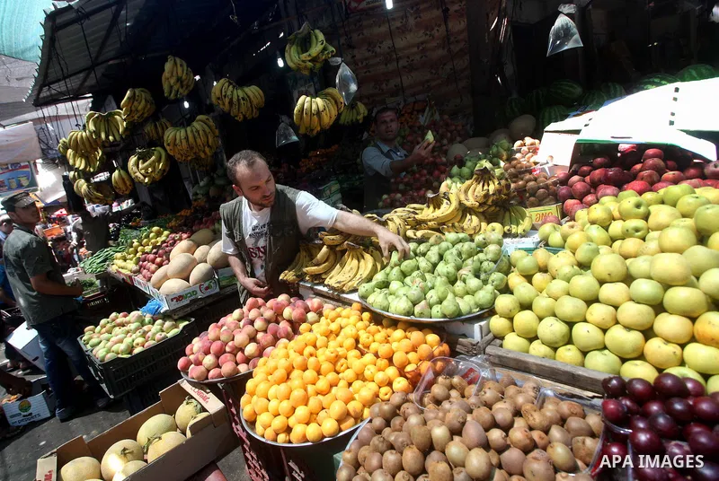 A Palestinian man buys vegetables and fruits in his shop at the popular AlZawya market in Gaza City on June. 12, 2012 . Photo by Ashraf Amra