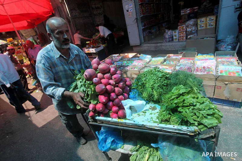 A Palestinian man buys vegetables at the popular AlZawya market in Gaza City on June. 12, 2012 . Photo by Ashraf Amra