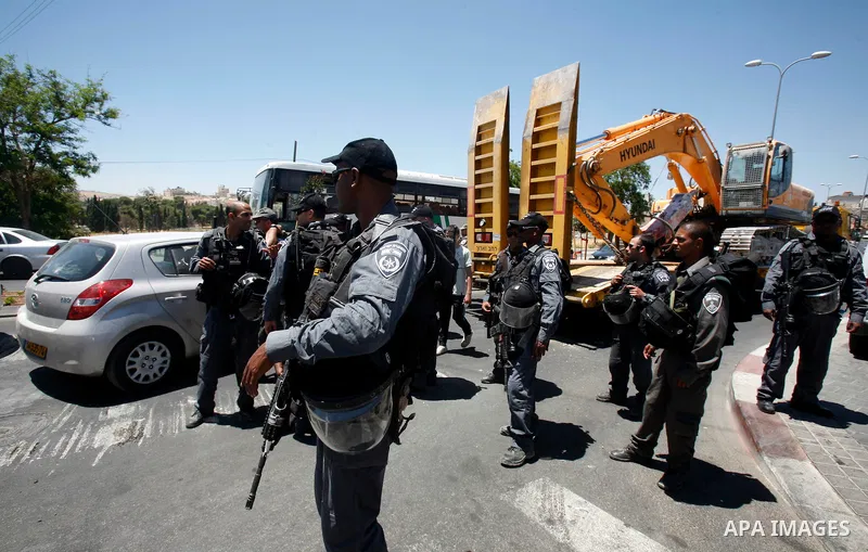 Israeli forces monitor the destruction of six Palestinian owned shops that were built without a permit in the neighbourhood of Beit Hanina, in east Jerusalem, on June 12, 2012. Israel revoked the residency of nearly 250,...