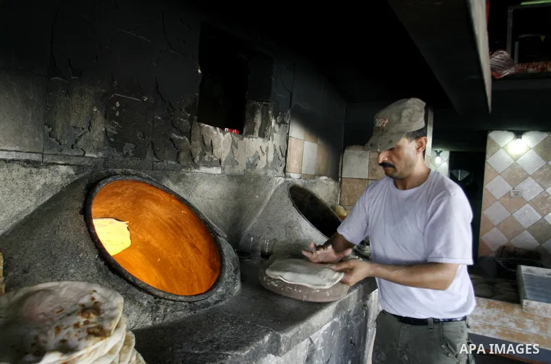 A Palestinian baker prepares bread at his bakery in Rafah, southern Gaza Strip on June 13, 2012. The European Union's envoy to the Palestinian Authority confirmed its support and allegiance to the people. Photo by Eyad A...
