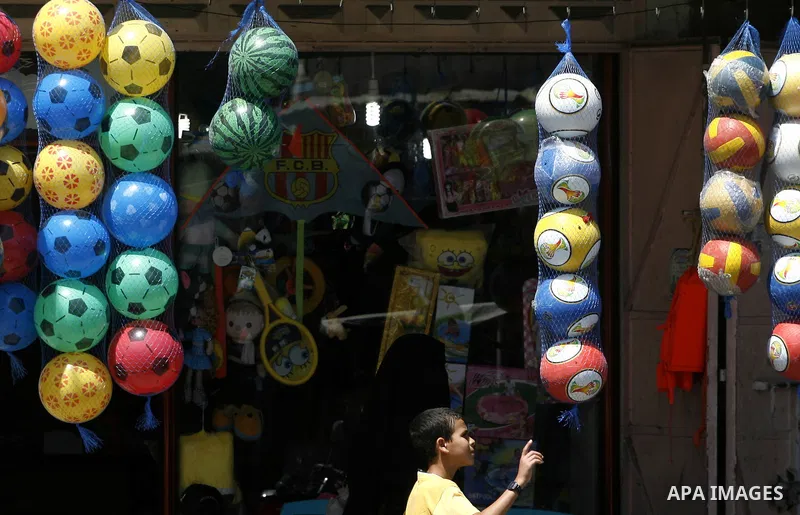A Palestinian man stands in his games for shoes at market Rafah, southern Gaza city, on June 13, 2012. Photo by Eyad Al Baba