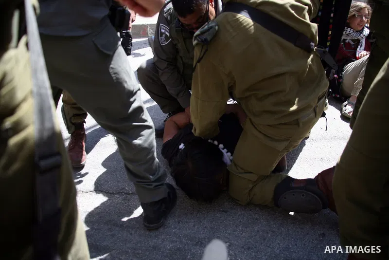 Israeli soldiers and border police try to arrest a demonstrator wearing a traditional Palestinian dress during a demonstration on al-Shuhada street against the closure of the central street in the West Bank town of Hebro...