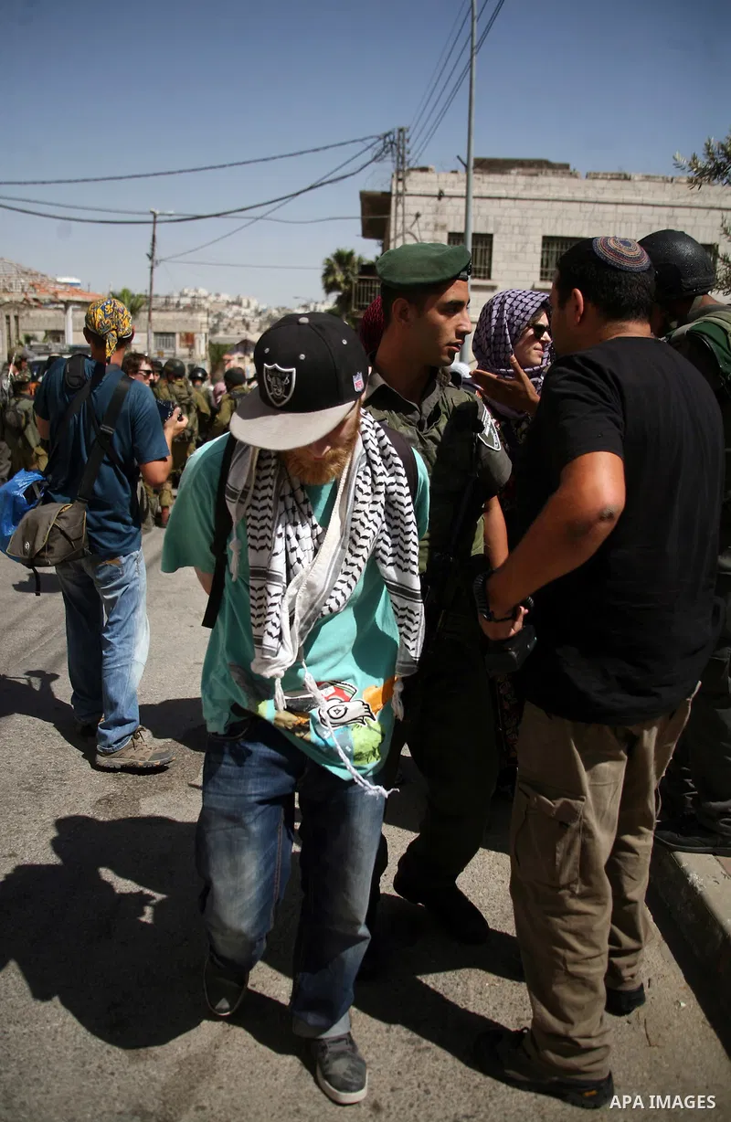 Israeli soldiers and border police try to arrest a demonstrator during a demonstration on al-Shuhada street against the closure of the central street in the West Bank town of Hebron, on June 13, 2012. The street is close...