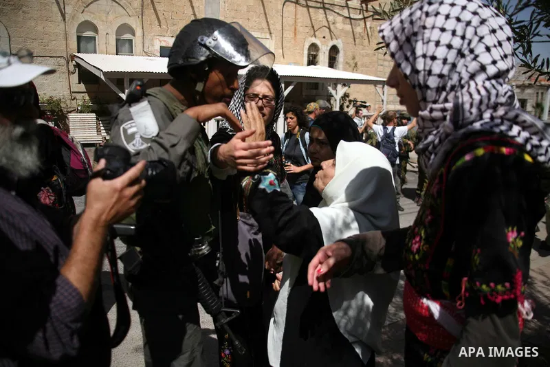 Israeli soldiers and border police try to arrest a demonstrator wearing a traditional Palestinian dress during a demonstration on al-Shuhada street against the closure of the central street in the West Bank town of Hebro...