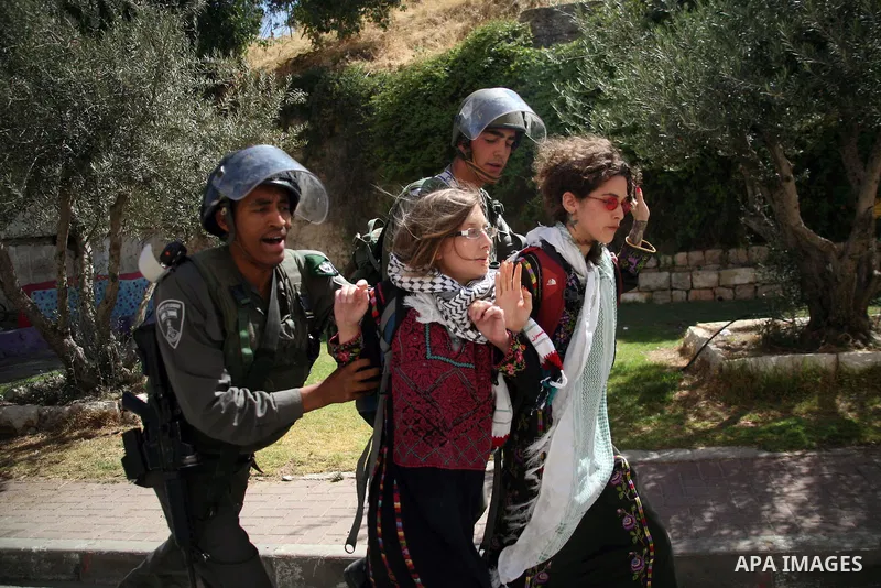 Israeli soldiers and border police try to arrest a demonstrator wearing a traditional Palestinian dress during a demonstration on al-Shuhada street against the closure of the central street in the West Bank town of Hebro...