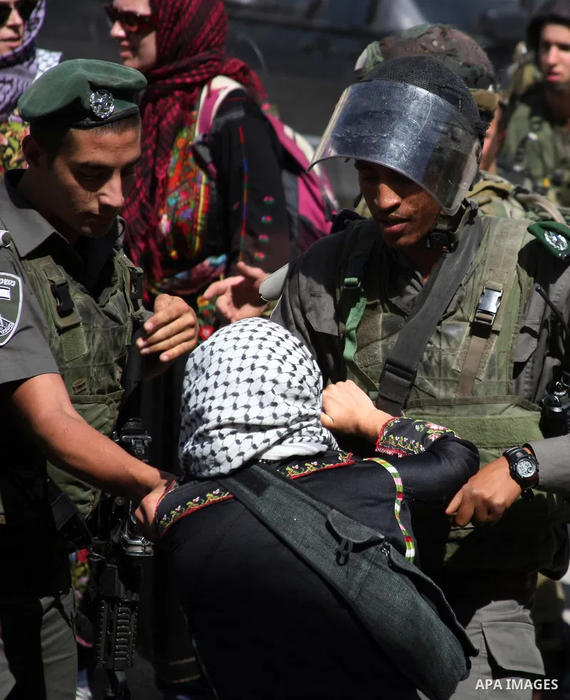 Israeli soldiers and border police try to arrest a demonstrator wearing a traditional Palestinian dress during a demonstration on al-Shuhada street against the closure of the central street in the West Bank town of Hebro...