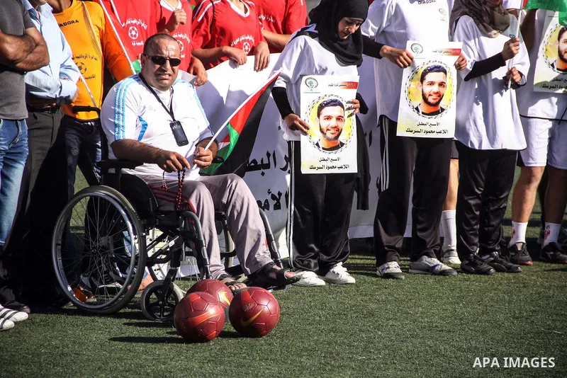 Palestinian athletes hold pictures and banners for prisoner Mahmoud Sarsak, a former player with the Palestinian national football team held in Israeli jails, during a protest calling for release him, at Al-Bireh playgro...
