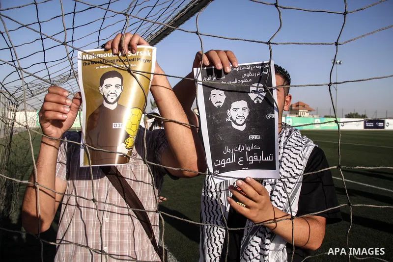 Palestinian athletes hold pictures and banners for prisoner Mahmoud Sarsak, a former player with the Palestinian national football team held in Israeli jails, during a protest calling for release him, at Al-Bireh playgro...