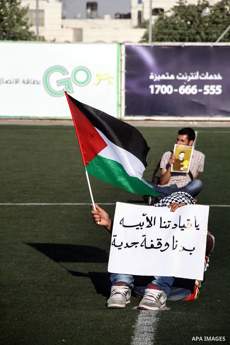 Palestinian athletes hold pictures and banners for prisoner Mahmoud Sarsak, a former player with the Palestinian national football team held in Israeli jails, during a protest calling for release him, at Al-Bireh playgro...