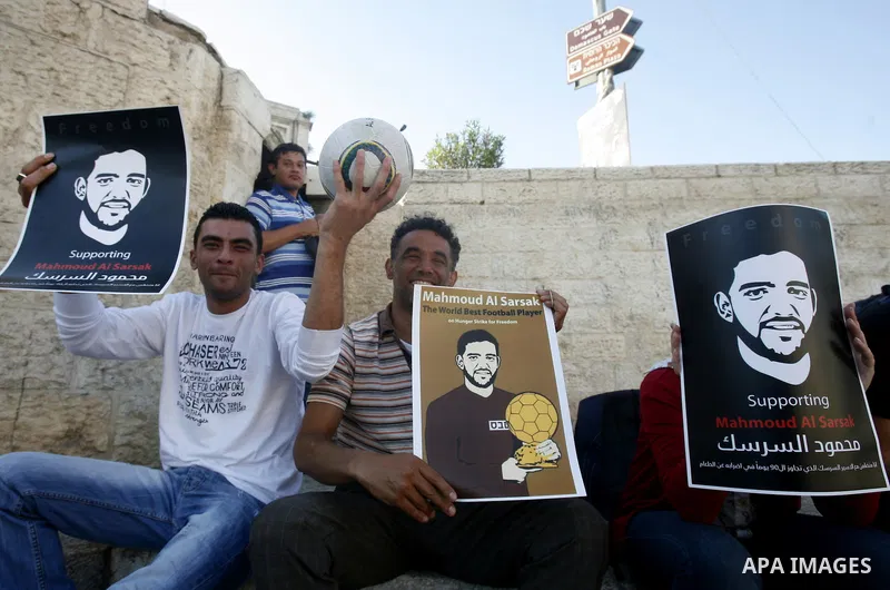 Palestinians hold posters depicting footballer Mahmoud Al-Sarsak, who is protesting his alleged illegal detention by Israel, during a rally in the old city of Jerusalem on June 13, 2012. FIFA president Sepp Blatter has e...