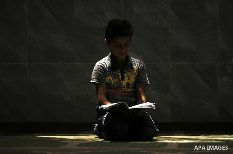A Palestinian boy reads verses from the Quran during a class on how to read Islam's holy book, at a mosque in Rafah, southern Gaza city, on June 14, 2012. A summer camp in the Gaza Strip, 'Crown of Dignity IV', plans to...