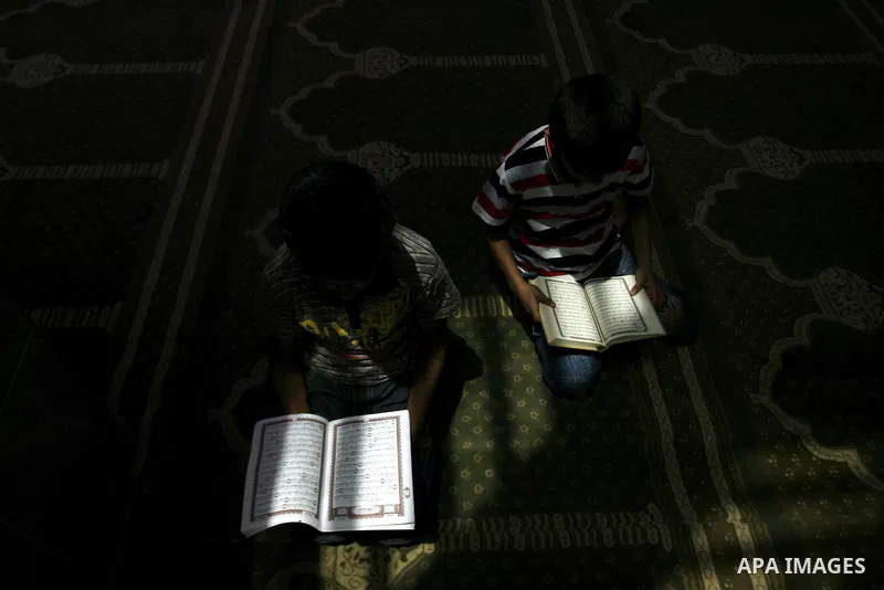 Palestinian boys read verses from the Quran during a class on how to read Islam's holy book, at a mosque in Rafah, southern Gaza city, on June 14, 2012. A summer camp in the Gaza Strip, 'Crown of Dignity IV', plans to te...