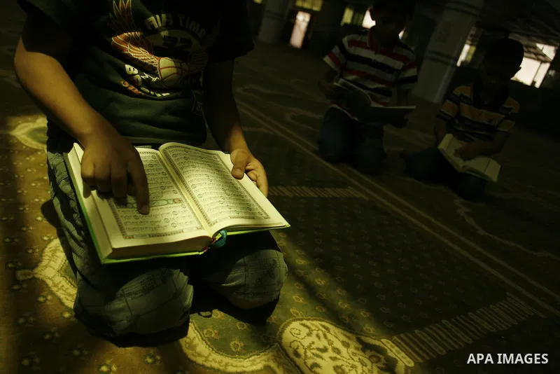 Palestinian boys read verses from the Quran during a class on how to read Islam's holy book, at a mosque in Rafah, southern Gaza city, on June 14, 2012. A summer camp in the Gaza Strip, 'Crown of Dignity IV', plans to te...