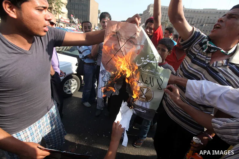 Egyptian protesters burn a placard against presidential candidate Ahmed Shafik during a protest at Cairo's Tahrir square, Egypt, 14 June 2012. Media reports on 14 June state that the Supreme Constitutional Court ruled th...