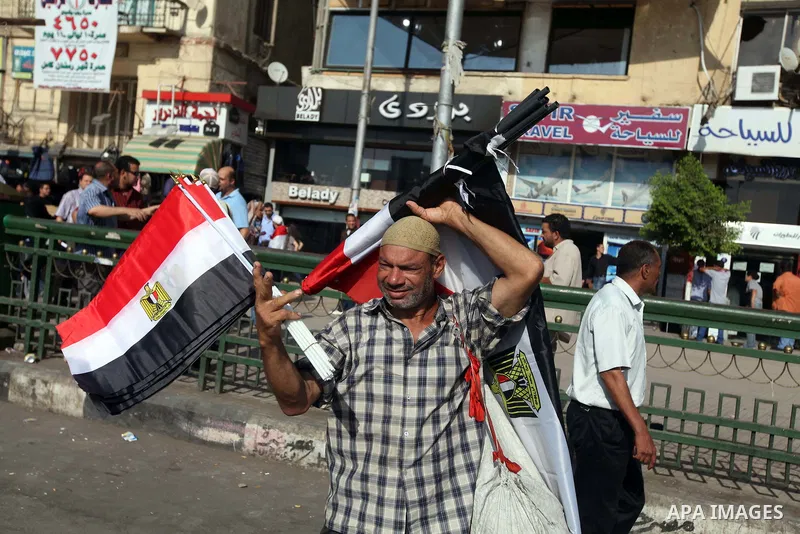 An Egyptian sells a national flags during a protest against presidential candidate Ahmed Shafik at Cairo's Tahrir square, Egypt, 14 June 2012. Media reports on 14 June state that the Supreme Constitutional Court ruled th...