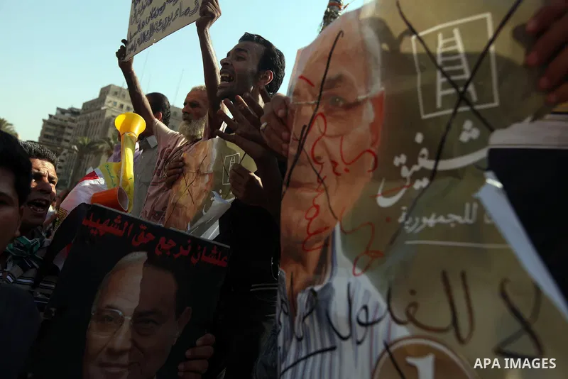 Egyptian protesters hold a placard against presidential candidate Ahmed Shafik during a protest at Cairo's Tahrir square, Egypt, 14 June 2012. Media reports on 14 June state that the Supreme Constitutional Court ruled th...