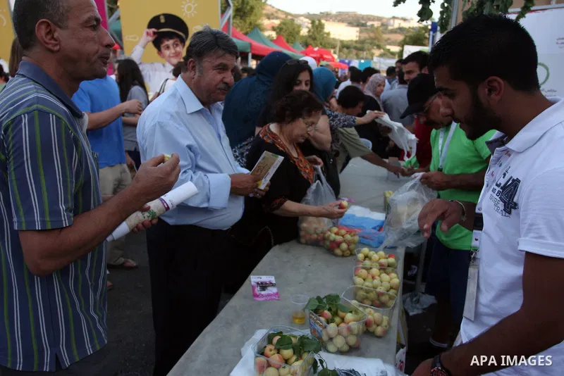 Palestinians take part in the opening of "Apricot Exhibition" in the village of Jaffna in the West Bank city of Ramallah, Thursday June 14, 2012. Photo by Issam Rimawi