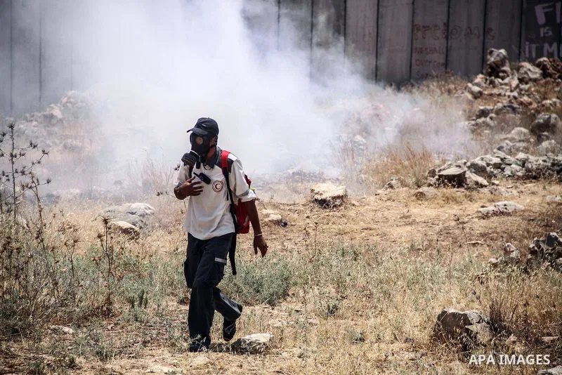 Palestinian medic walks during a weekly demonstration against Israel's controversial separation barrier in the West Bank village of Nilin on June 15, 2012. When completed, 85 percent of the wall will have been built insi...
