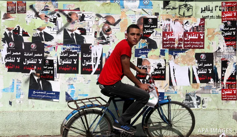 An Egyptian man rides a bicycle in front of a polling station on June 15, 2012 on the eve of Egypt's second round of presidential runoff elections. Egypt's transition to democracy was thrown into further disarray after i...
