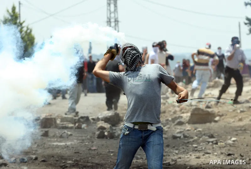 A Palestinian Protester returns a teargas towards Israeli soldiers during clashes in the northern West Bank village of Kufr Qaddum, after the weekly protest against the expansion of the nearby Jewish settlement of Kdumim...