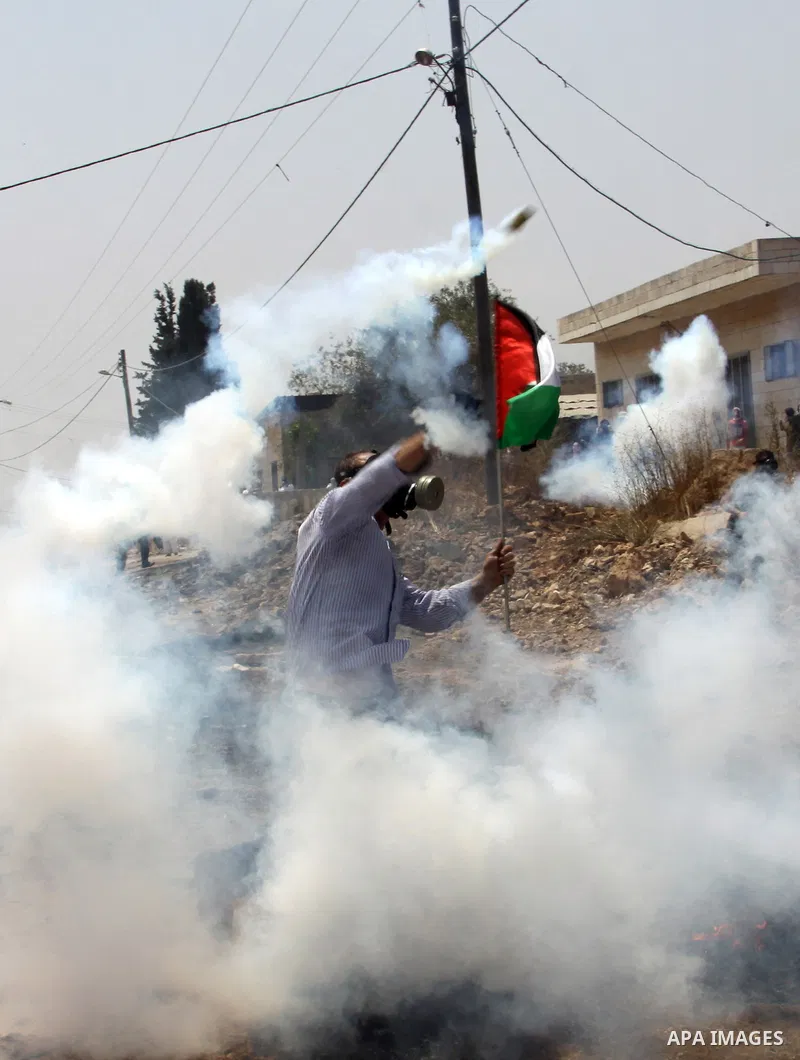 A Palestinian Protester returns a teargas towards Israeli soldiers during clashes in the northern West Bank village of Kufr Qaddum, after the weekly protest against the expansion of the nearby Jewish settlement of Kdumim...