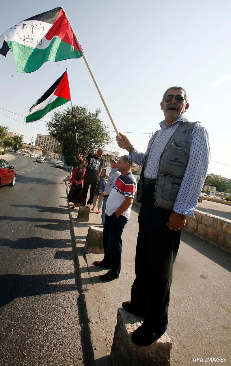 Palestinians hold national flags and banners during a protest against land confiscation in the neighborhood of Sheikh Jarrah in the east Jerusalem on 15 June, 2012. Photo by Mahfouz Abu Turk