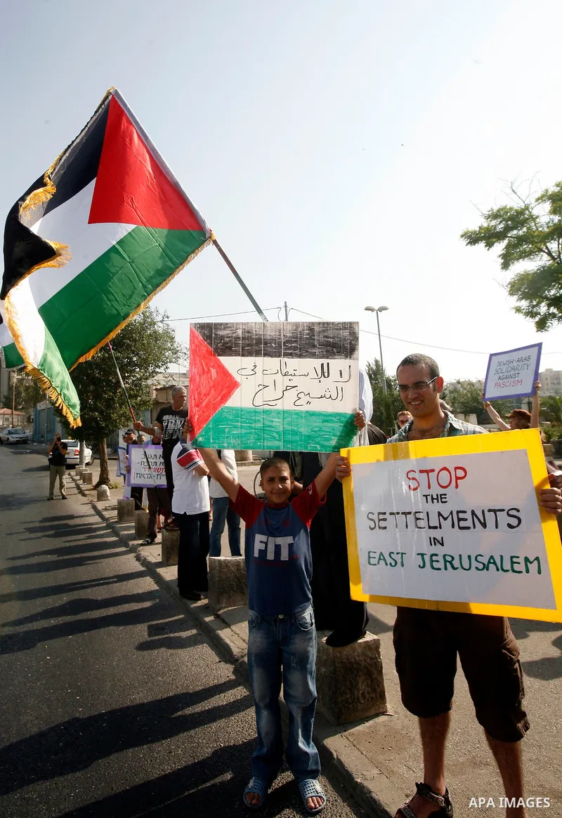 Palestinians hold national flags and banners during a protest against land confiscation in the neighborhood of Sheikh Jarrah in the east Jerusalem on 15 June, 2012. Photo by Mahfouz Abu Turk