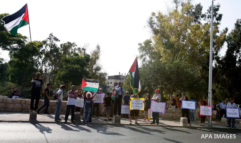 Palestinians hold national flags and banners during a protest against land confiscation in the neighborhood of Sheikh Jarrah in the east Jerusalem on 15 June, 2012. Photo by Mahfouz Abu Turk