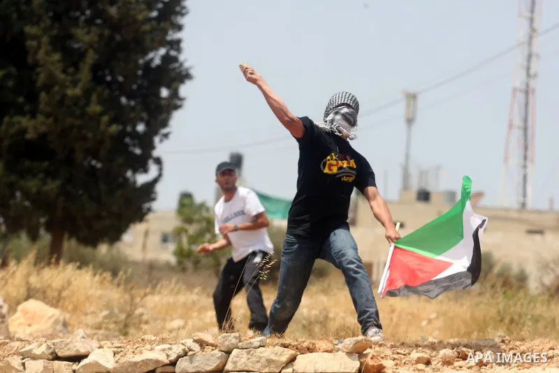 Palestinian protesters throw stones at Israeli soldiers during clashes in the West Bank village of Nabi Saleh, near Ramallah, on June 15, 2012, following a demonstration against the confiscation of Palestinian land to ex...