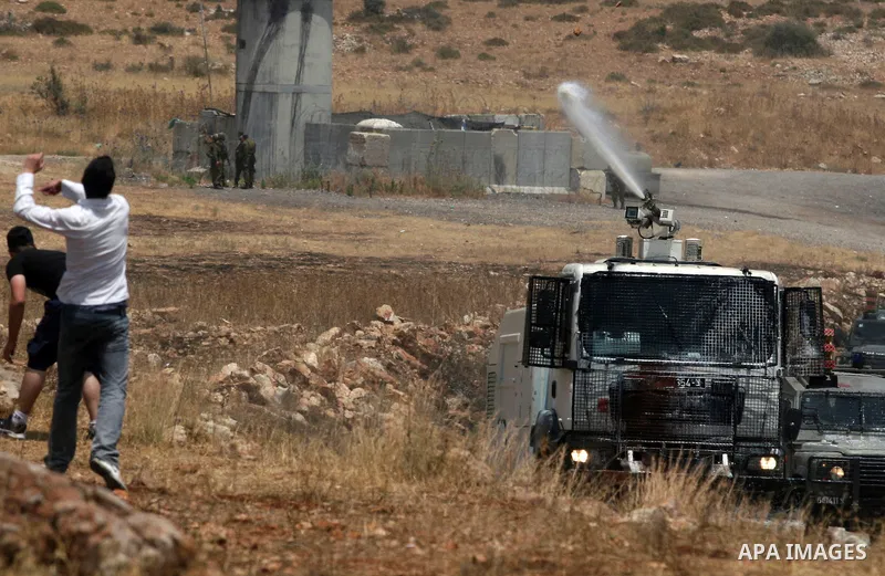 Israeli truck spray foul smelling water towards Palestinian protesters during clashes in the West Bank village of Nabi Saleh, near Ramallah, on June 15, 2012, following a demonstration against the confiscation of Palesti...