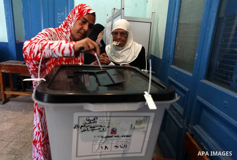 Egyptian women cast their vote at a polling station in Cairo on June 16, 2012 in a divisive presidential runoff pitting ousted strongman Hosni Mubarak's last premier Ahmed Shafiq against Muslim Brotherhood candidate Moha...