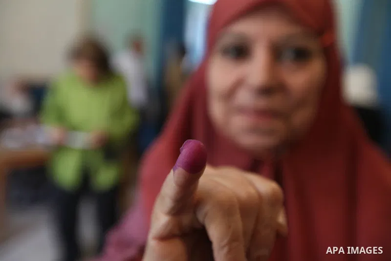 An Egyptian woman shows her ink-stained finger after casting her vote at a polling station in Cairo on June 16, 2012 in a divisive presidential runoff pitting ousted strongman Hosni Mubarak's last premier Ahmed Shafiq ag...