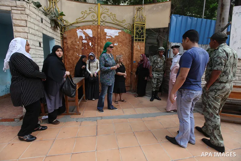 Egyptian women wait outside a polling station in Cairo to cast their votes on June 16, 2012 in a divisive presidential runoff pitting ousted strongman Hosni Mubarak's last premier Ahmed Shafiq against Muslim Brotherhood...
